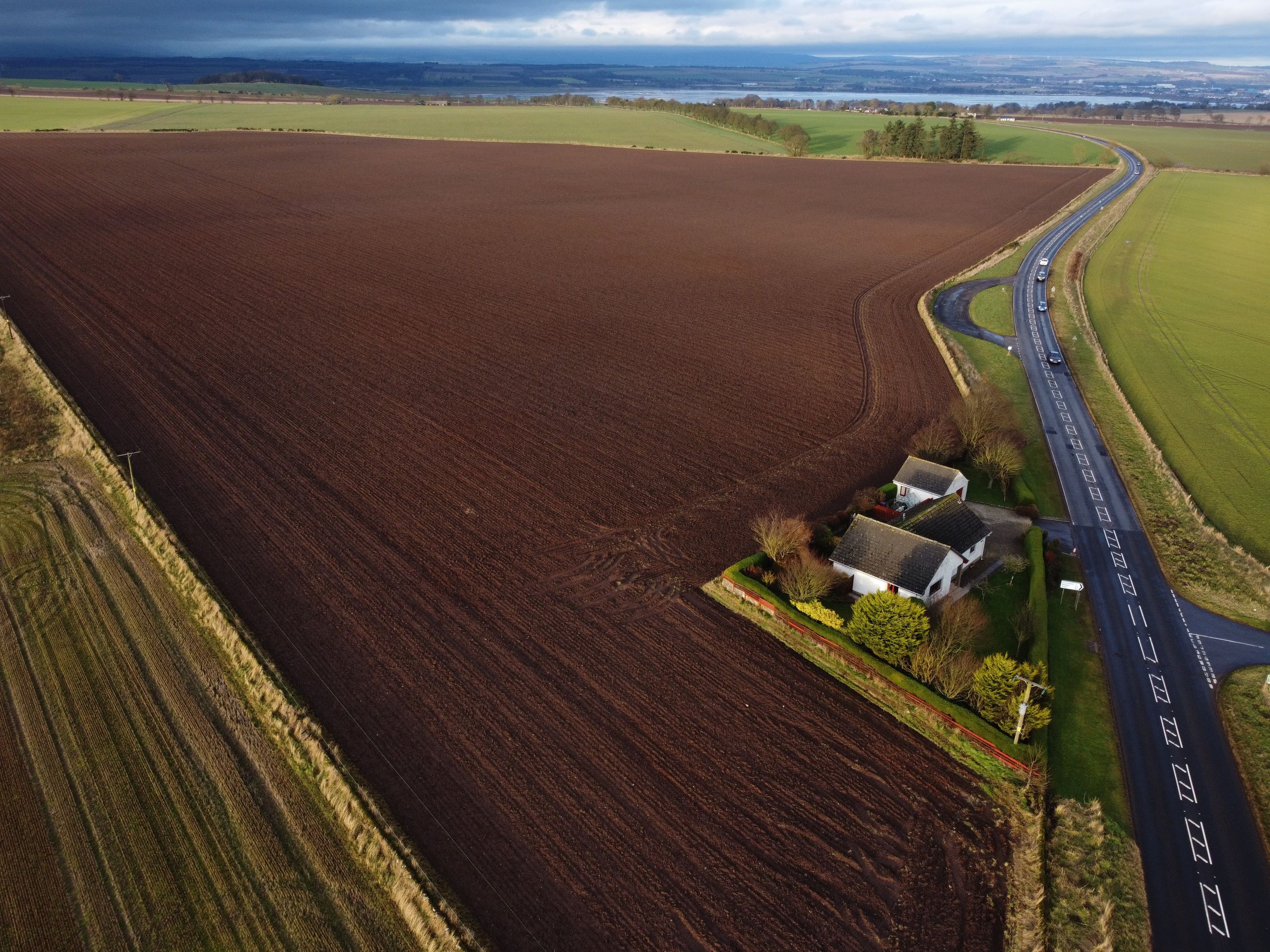 loans against land. Aerial shot of expansive farmland with a house